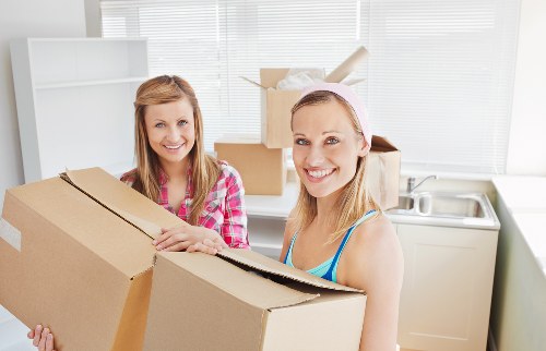 Local movers handling desks and boxes during an office move